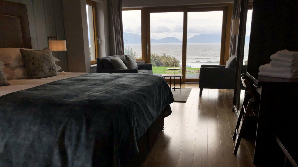 Luxury Seaside Room with View Elegant hotel room with plush bed, cosy seating, and stunning ocean view, perfect for a relaxing seaside retreat.